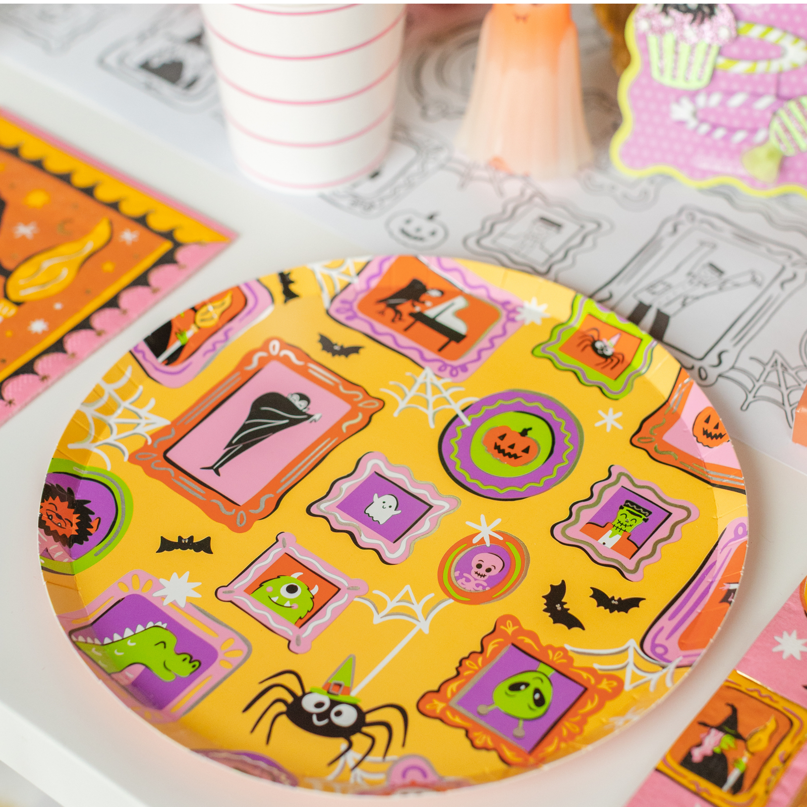 Monster Mash framed-monster round plate on a coloring placemat with cups and ghost decor.