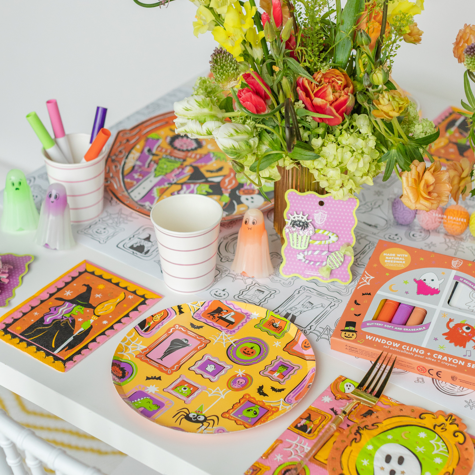 Monster Mash table with framed-monster plates, a window-cling crayon set, florals, and ghost figures.