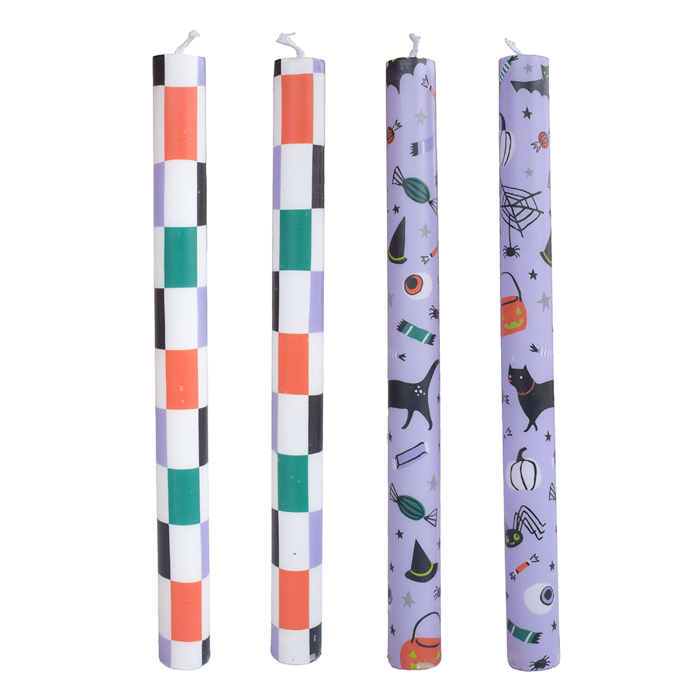 Four taper candles: two in a checkered print, two in a lavender Halloween-icon print.