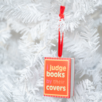 I Judge Books By Their Covers Book Ornament, styled on a tree.
