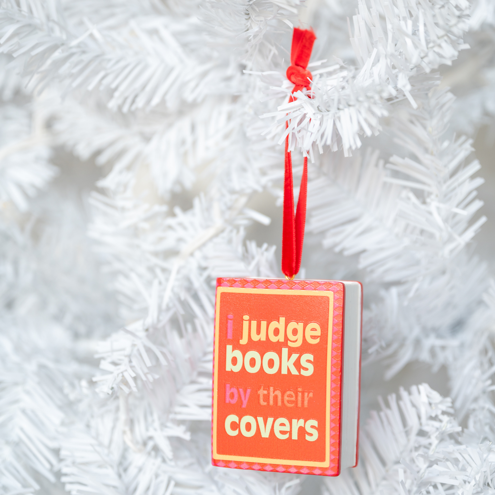 I Judge Books By Their Covers Book Ornament, styled on a tree.